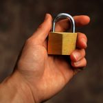 Hand holding secure padlock cybersecurity concept