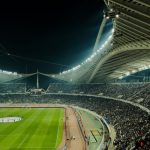 Football stadium illuminated at night with crowd