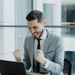 Person celebrating progress while learning online on a laptop — best Coursera courses 2026