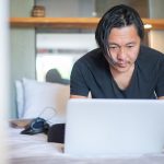 Freelancer working on laptop in bright home office