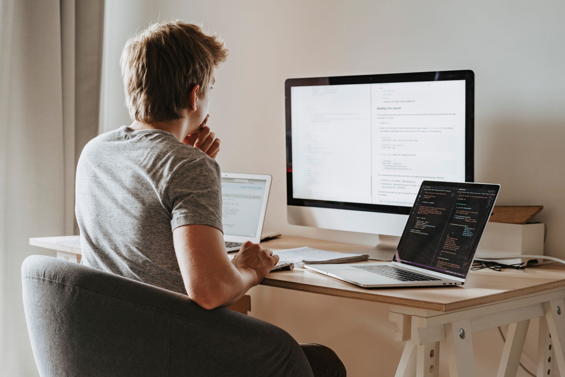 Female developer coding on multiple monitors