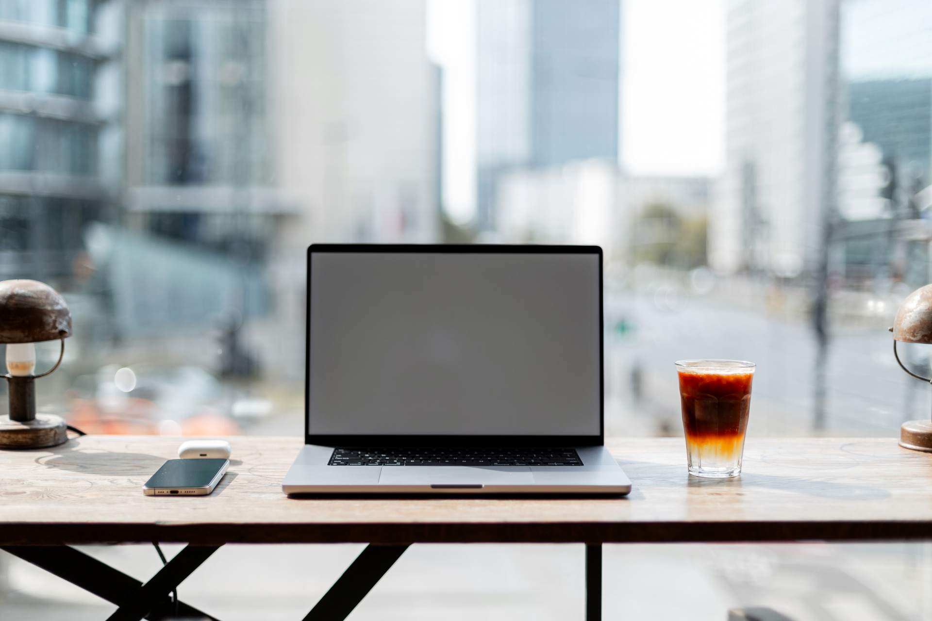 MacBook Air M4 laptop on wooden desk with coffee and notebook